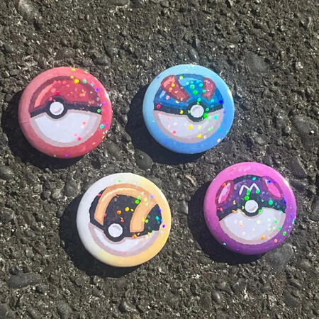 badges featuring the designs of four different poke balls